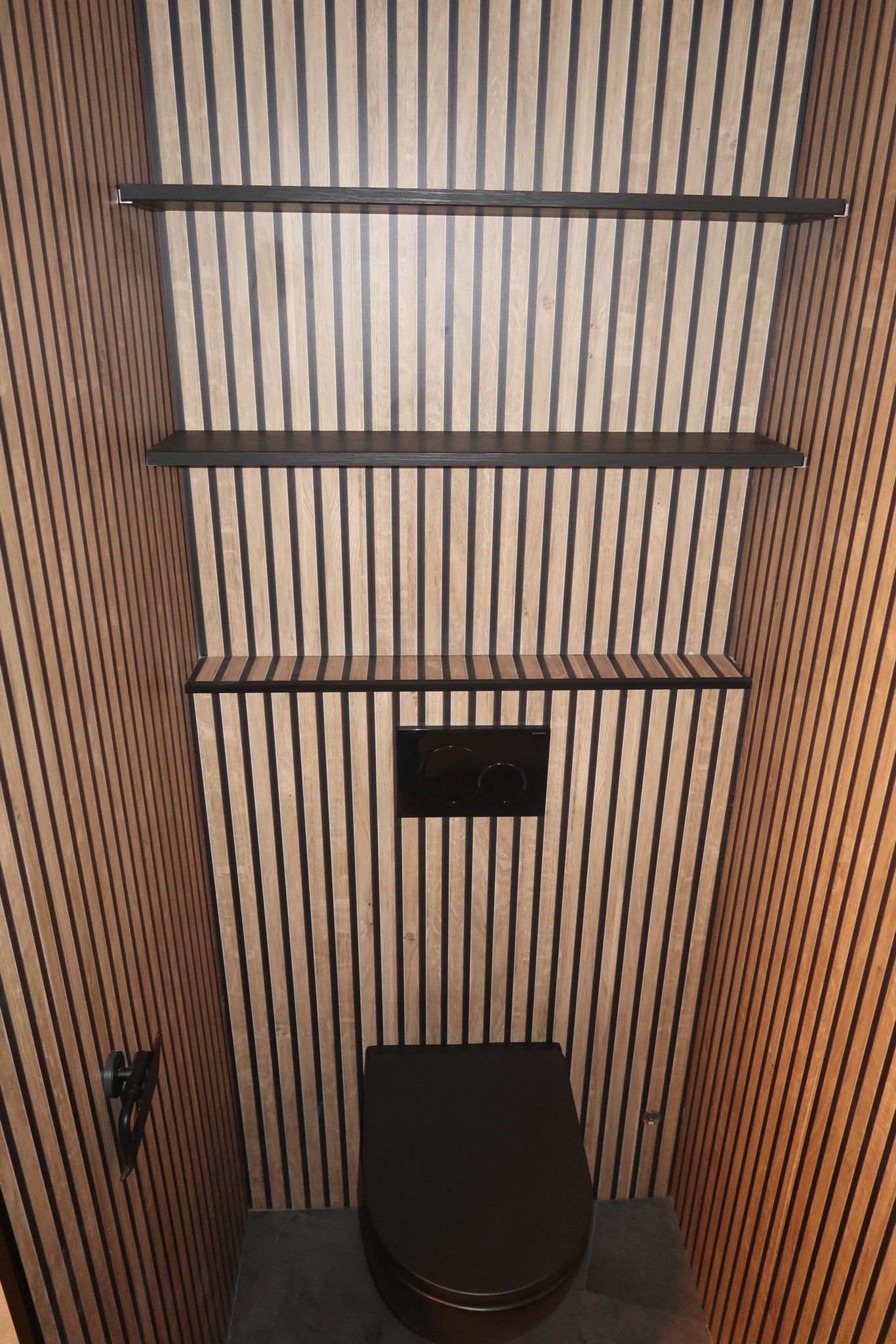 Modern toilet met houtlook ribpanelen, zwarte accenten en een wandcloset.